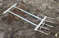 A digging fork or 'grelinette' with five teeth. It is used for loosening, lifting and turning over soil in gardening and farming. It has the advantage that it doesn't disturb the layers in the soil.